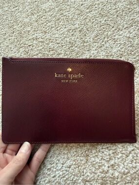 Kate Spade burgundy leather zip pouch with gold logo